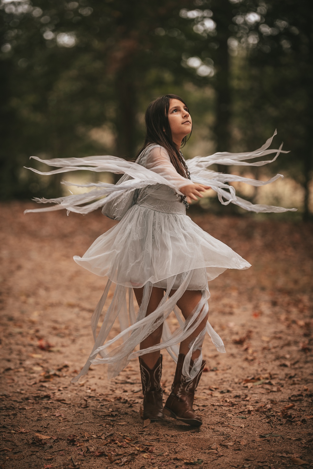 A child twirling, her costume flowing through an autumn woodland
